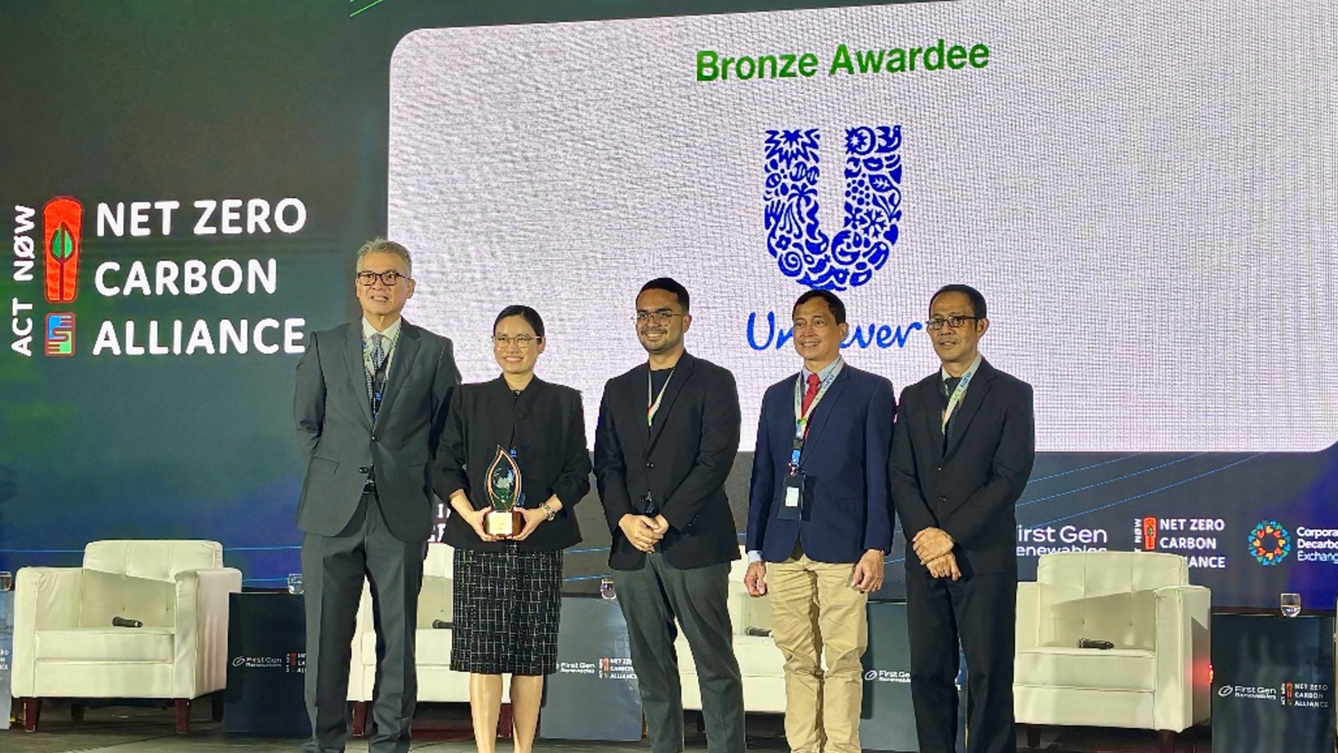 Unilever representatives receive a bronze award from the Net Zero Carbon Alliance.