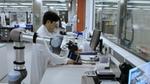 A scientist in a white coat standing in a laboratory, surrounded by various scientific equipment.