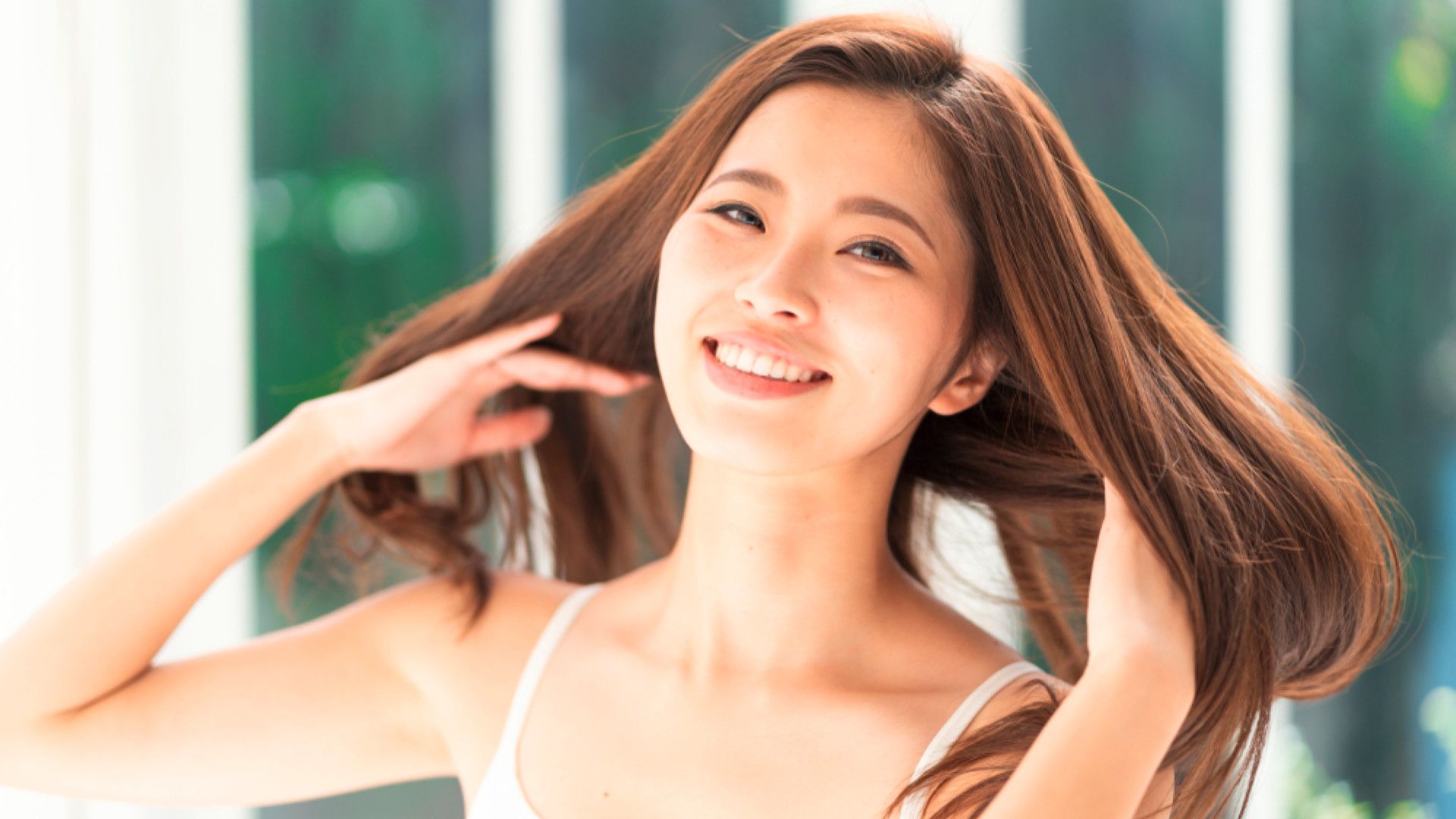 A woman flipping her light brown hair.
