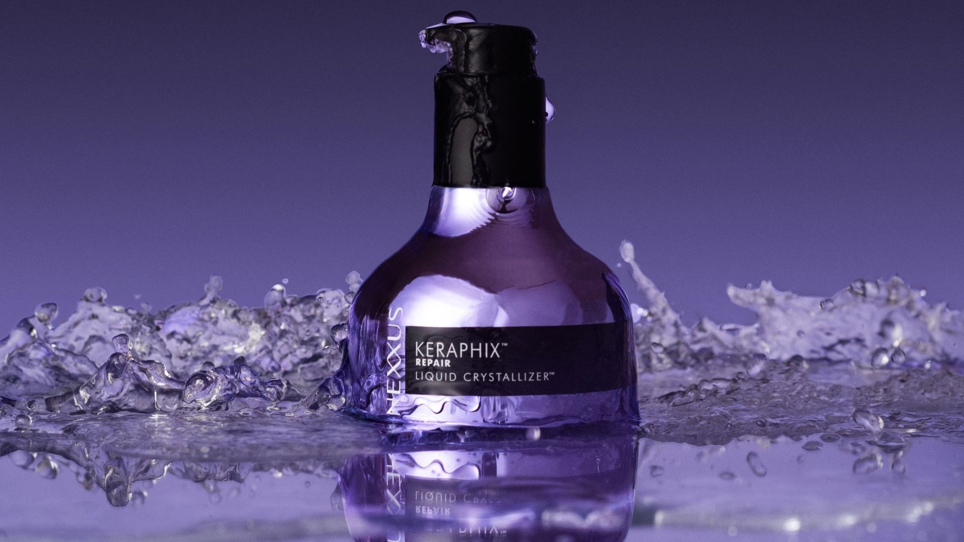 A bottle of Nexxus Keraphix Liquid Crystallizer. The bottle is a metallic silver-lilac colour with a black pump. 