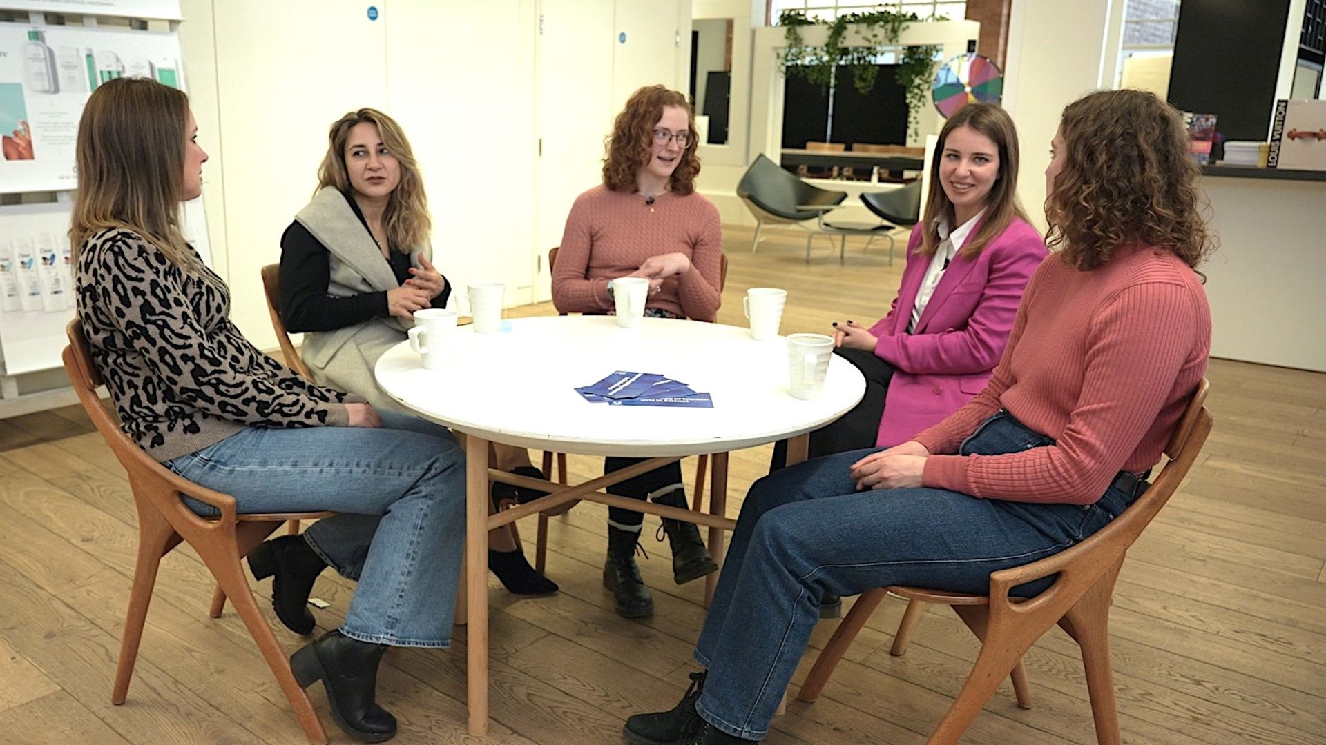A group of five women sitting together for a round-table discussion. They are all scientists in varied roles at Unilever.