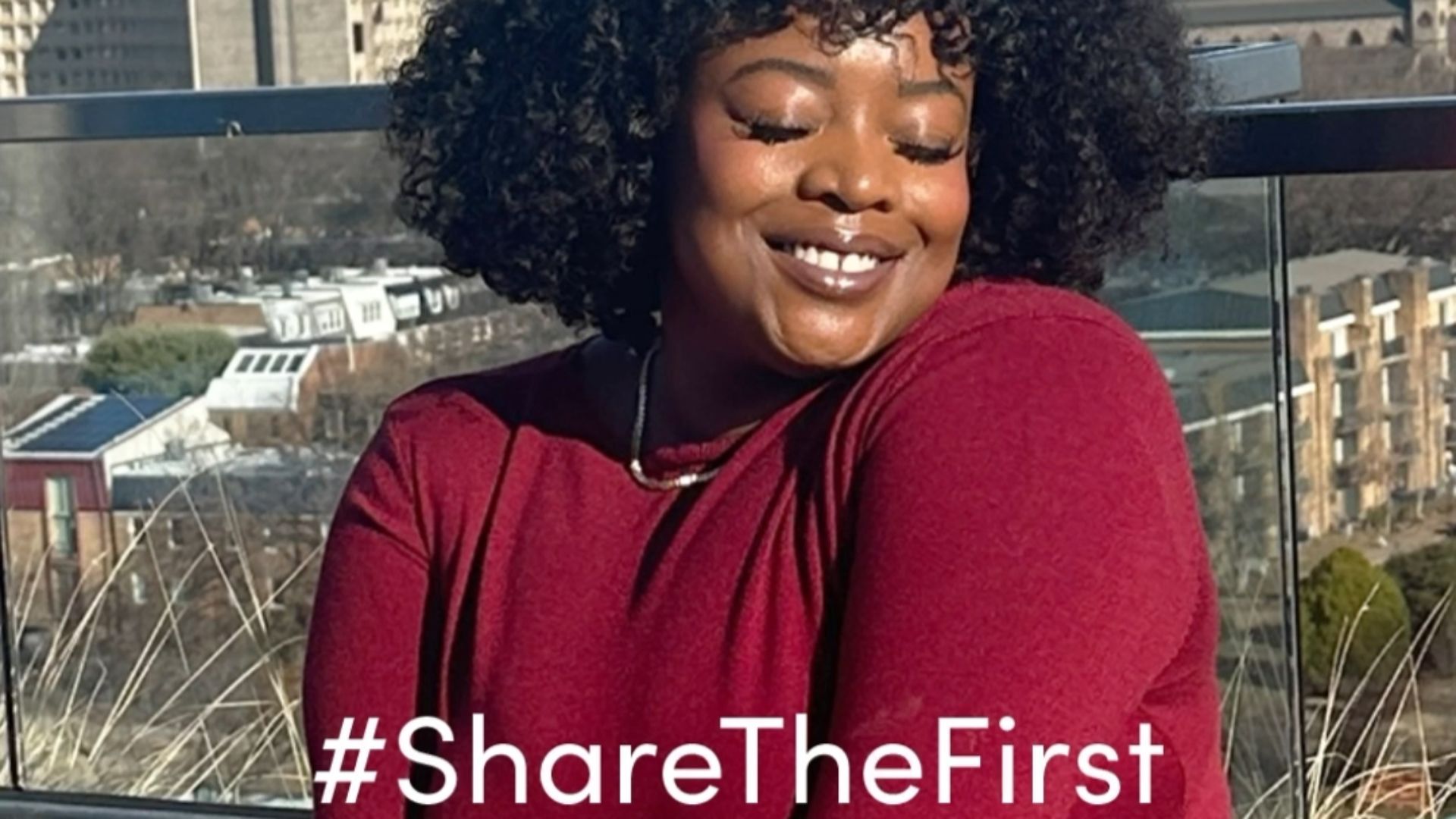A selfie of a woman in a red dress with dark curly hair with the tagline #ShareTheFirst 