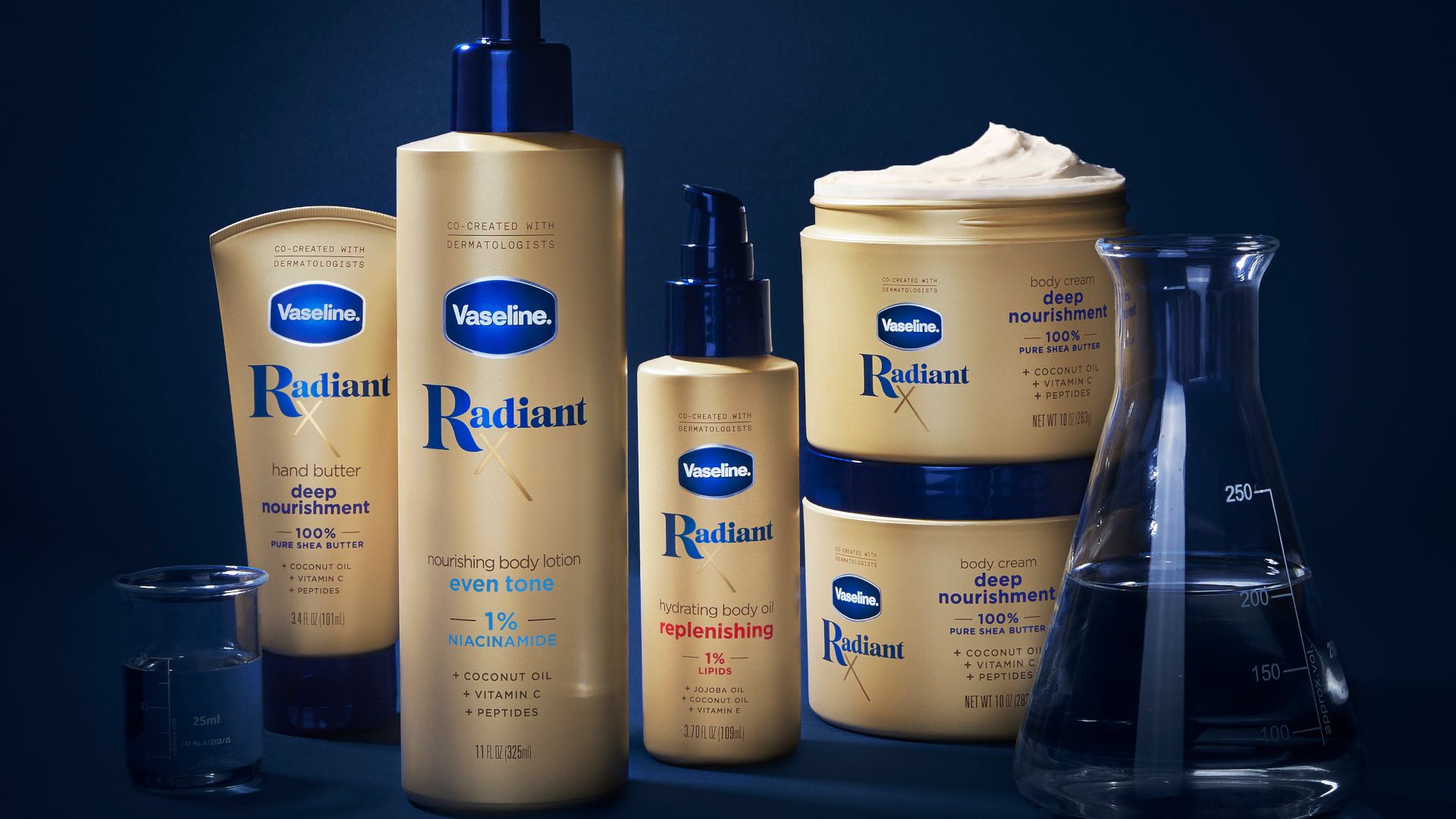 Products from Vaseline’s Radiant X collection, including Nourishing Body Lotion and Hydrating Body Oil. Packaging is golden on a dark blue background.