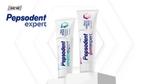 Two tubes of Pepsodent toothpaste displayed upright on white podiums. The left tube is labelled 'Pepsodent Sensitive Expert' and the right tube is labelled 'Pepsodent Gum Expert'. The background features a subtle geometric pattern in white.