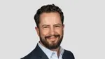 A photo of Leandro Barreto, Chief Marketing Officer for Unilever Beauty & Wellbeing. Leandro is a white man with dark hair and a beard, smiling at the camera.