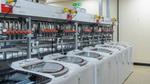 A row of eight top-loading washing machines at Unilever’s laundry detergent testing lab at Port Sunlight in the UK.