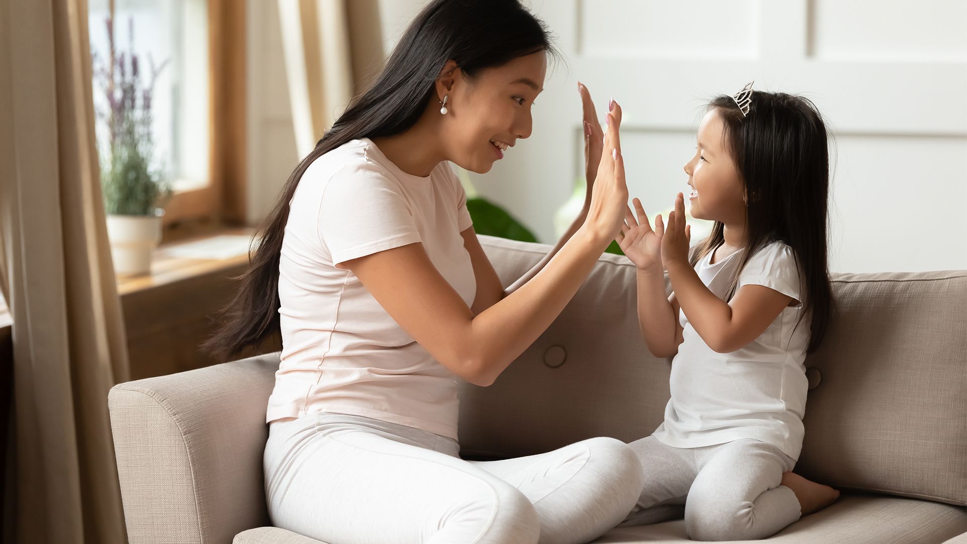 A mother and daughter high fiving each other